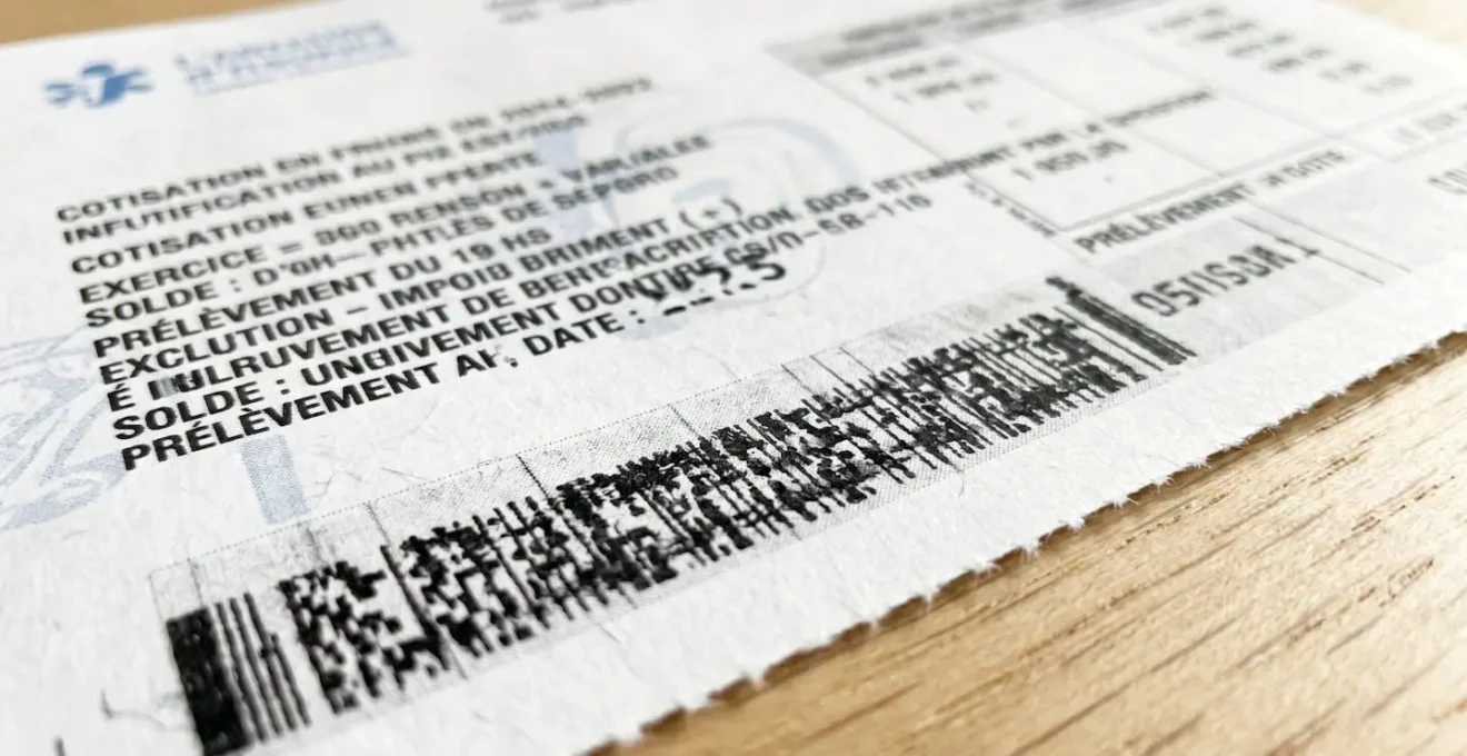 Gros plan sur un document comptable français avec une calculatrice moderne posée à côté, mise au point sélective sur une ligne de revenus, arrière-plan flouté