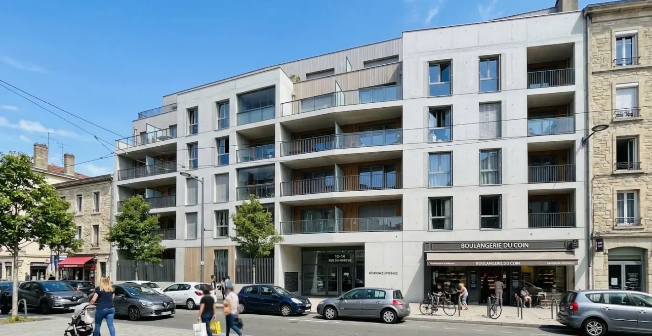 Façade d'un immeuble résidentiel contemporain français avec balcons, grandes fenêtres et ciel dégagé en arrière-plan
